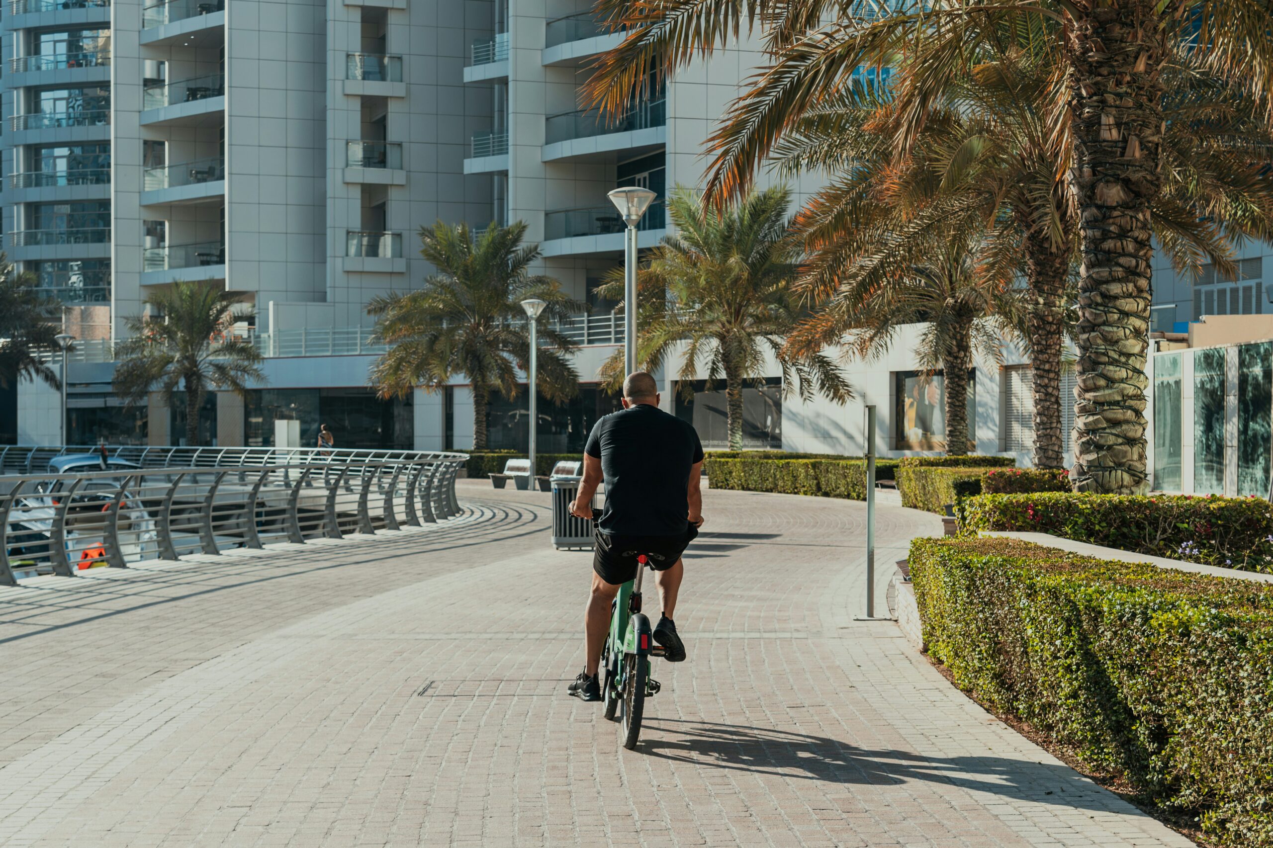 A man riding a bike down a street next to tall buildings